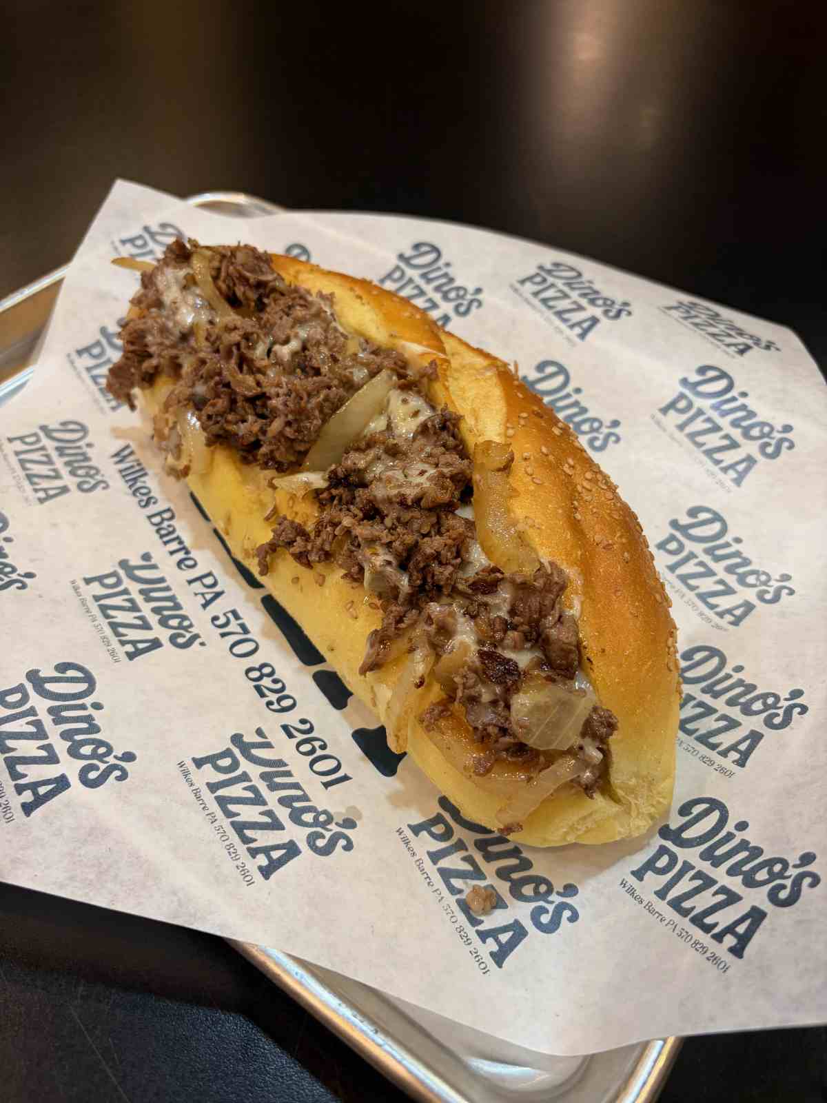 Loaded cheesesteak sub with melted provolone and sauteed peppers